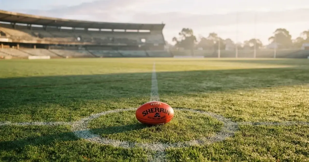 A ball on the centre spot of a grass pitch in morning light